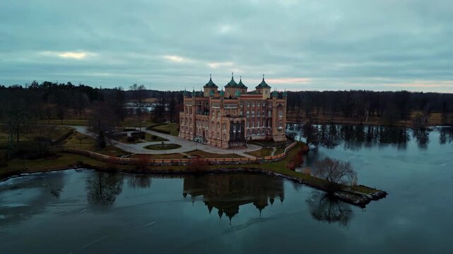 Aerial view of the magnificent Stora Sundby Castle reflecting in the calm lake, a scene of serene beauty and architectural splendor, Stora Sundby, Sodermanlands lan, Sweden.