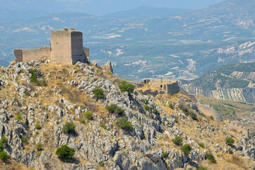 Obraz premium Acrocorinth fortress ruins overlooking the Corinthian valley. Acrocorinth fortress ruins standing on a rocky hill under a clear sky. Peloponnese, Greece
