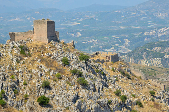 Acrocorinth fortress ruins overlooking the Corinthian valley. Acrocorinth fortress ruins standing on a rocky hill under a clear sky. Peloponnese, Greece