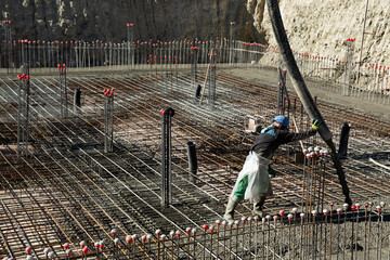 Obrero echando hormig&oacute;n en estructura de un edificio en construcci&oacute;n.