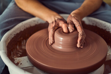 Potter Shaping Brown Clay On Pottery Wheel With Muddy Hands In Studio Ceramics Process