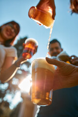People holding beer cups and enjoying summertime outdoors.