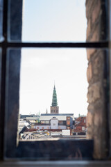 View of Nikolaj Kunsthal tower through a window. Skyline of copenhague.