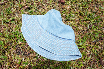 A light blue denim bucket hat placed on a grassy surface. Top view Flat lay.