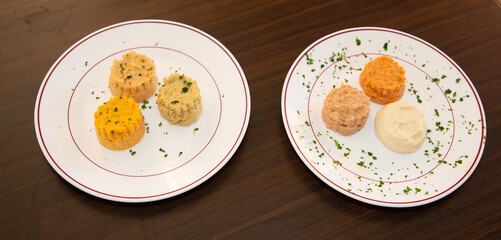 two white plates three savory vegetable mousses french purees garnished with parsley