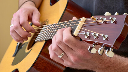 Close-up of male hands playing acoustic guitar