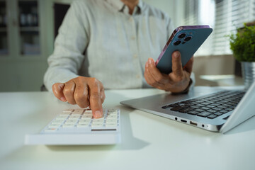 Business women using calculator with smartphone and computer laptop, Business accounting, budget and loan in office.