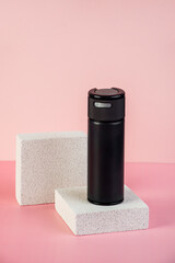 Black cosmetic product or sunscreen cosmetic with stylish props on pink background.