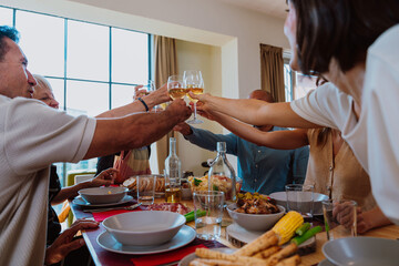 Family and friends reunion at home. Diverse family and friends celebrating together making a toast
