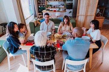 Family and friends reunion at home. Multi-generational family gathering having lunch at home