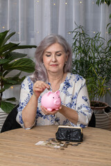 An elderly woman pensioner and a piggy bank in the shape of a pig
