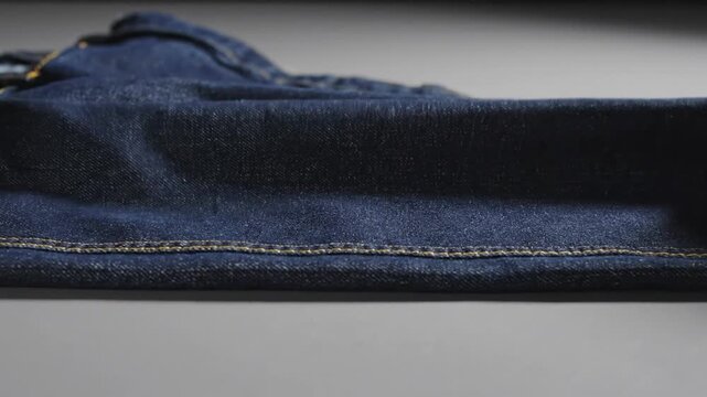 Blue denim fabric with orange stitching close up texture detail textile pattern clothing material seam macro