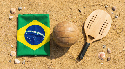 Brazil flag on sand with a ball and paddle for beach volleyball game preparation