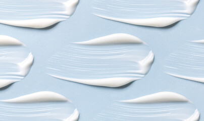 pattern of cream smears of creamy texture on blue background