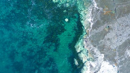 Drone aerial landscape of waves breaking along seaweed sandbar reef in ocean bay inlet on beach coastline and rocky headland of Gerroa Gerringong South Coast Australia travel tourism fishing surfing - Powered by Adobe