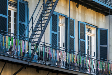 Fototapeta premium Mardi Gras beads on a balcony on a building in a street of the French Quarter, New Orleans architecture, Louisiana