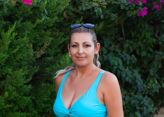 portrait of a beautiful young woman smiling at camera in the garden	