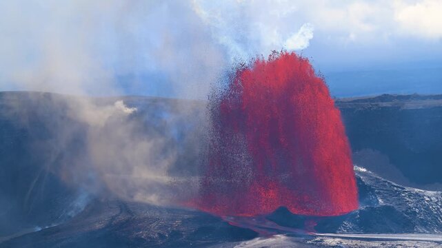 Aerial view of volcano spewing bright red lava against the dark, textured landscape, creating a striking contrast of colors and forces, Kilauea, Hawaii, United States.