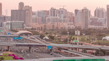 Obraz premium Dubai Golf Course with a cityscape of Greens and tecom districts at the background aerial night to day timelapse