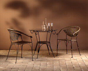 Still life of wicker and iron armchairs on a stone floor