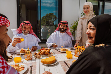 Muslim family members enjoying a traditional meal outdoors