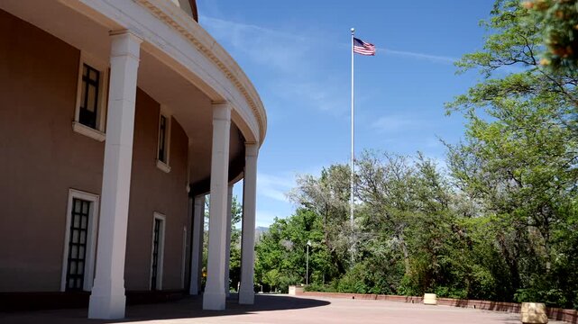 An American flag flies alongside The Roundhouse, New Mexico&rsquo;s state capitol building, in Santa Fe