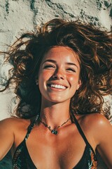 A beautiful young woman on the beach lies on the sand and smiles