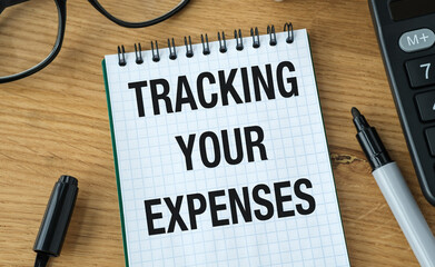 A notebook with the words Tracking Your Expenses written on it.