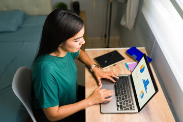 Woman working on laptop, analyzing data and charts from home, remote work, online learning, e-learning