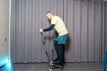 An athlete performs an exercise on a fitness machine. Home cardio workout. Caring for a healthy body.