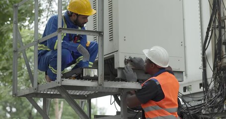 Telecom engineer and technician inspect communication equipment during network maintenance and upgrade operation. Infrastructure inspection, troubleshooting, cable management for reliable connectivity
