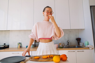 Lively scene with woman savoring orange and smiling broadly © teksomolika