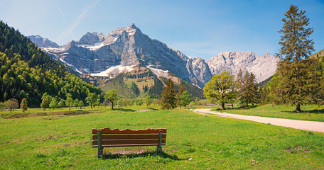 carved wooden bench with a stunning view to Spritzkarspitze, Karwendel alps in spring