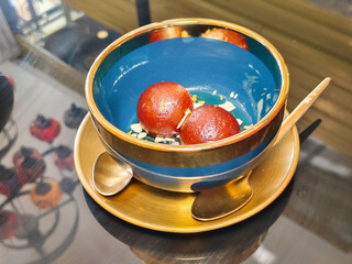 Close-up of Gulab jamun in a bowl at an Indian restaurant. Delicious traditional Indian food.