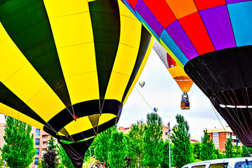 Colorful hot air balloon flying over blue sky with white clouds
