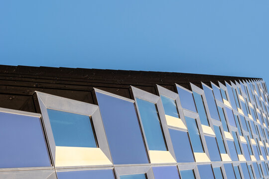 Geometric architecture facade with modern abstract building surfaces creating pattern, symmetry, reflection and minimalism in a structured visual design