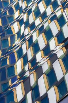 Abstract modern building facade featuring geometric pattern elements with symmetry, reflection and minimalism shaping a clean architectural composition