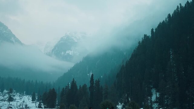 4k Winter mountain landscape with clouds and pine trees. Bad weather during winter day, view after fresh snowfall at Aru Valley, Jammu and Kashmir, India. Travel and holidays concept.