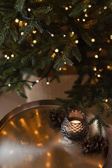 Blurred Christmas tree lights, golden tray and candle. Aesthetic winter holiday background