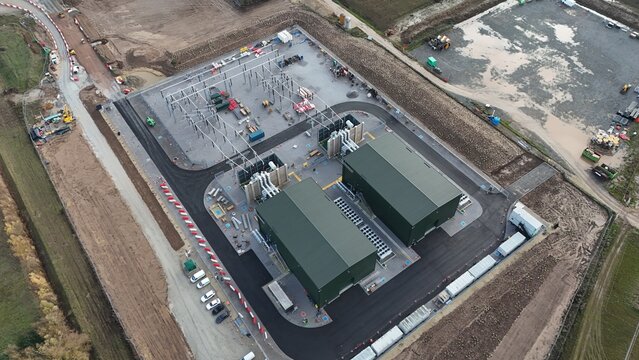 Aerial view of the industrial buildings standing starkly against the surrounding brown fields and newly constructed roads, Sutton Bridge, United Kingdom.