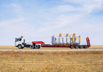 Heavy Machinery Transported on Flatbed Truck in Steppe Landscape © BaljK' RTE