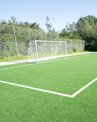 Bright, green soccer field with goal ready for play on a sunny day in a park