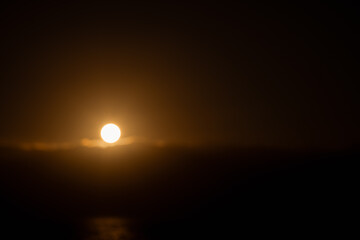 Minimalist sunset with soft-focus sun over the ocean in Tenerife. Warm golden tones and calm atmospheric mood.