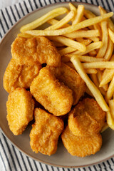 Chicken Nuggets with French Fries on a Plate, top view. Close-up.