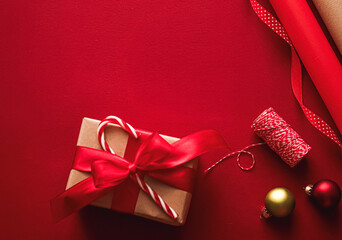Giving a Christmas gift with red ribbon and candy cane on a festive background, celebrating...