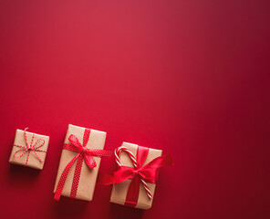 Christmas presents with red ribbon and candy cane on a festive deep red background, celebrating holiday giving