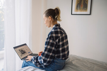 Woman examines travel options and plans itinerary using her computer