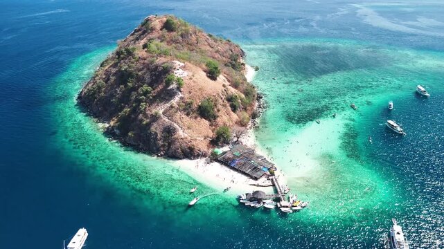 Scenic aerial panorama of Pulau Kelor Komodo Indonesia with boats moored along wooden pier