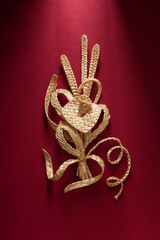 Decoration of straw on a red background. Branch with flowers. Boutonniere made out of straw. Brooch. Straw weaving.