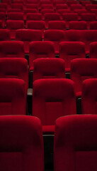 Fototapeta premium wide-angle shot of an empty movie theater with red seats, soft dim lighting, calm cinematic mood, no people.Empty Movie Theater Seats. Cinematic Empty Auditorium. Silent Cinema Hall.